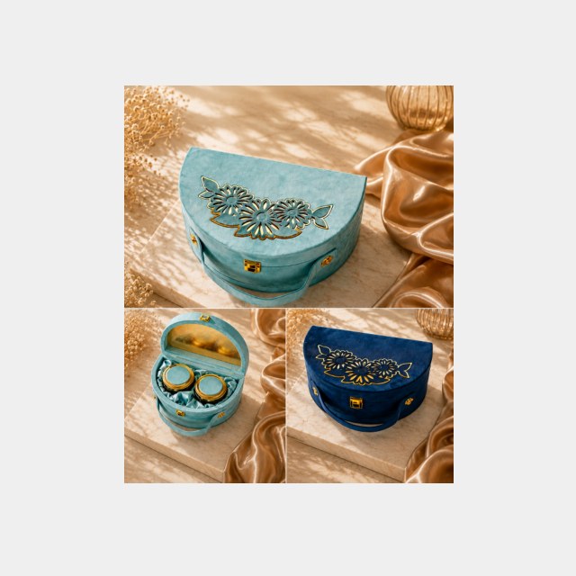 Teal velvet Diwali gift box with gold peacock emblem, two dry fruit jars and a diya set