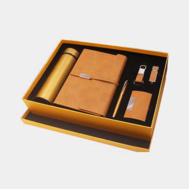Tan and mustard six-piece gift set with notebook, bottle, USB drive, metal pen and keychain