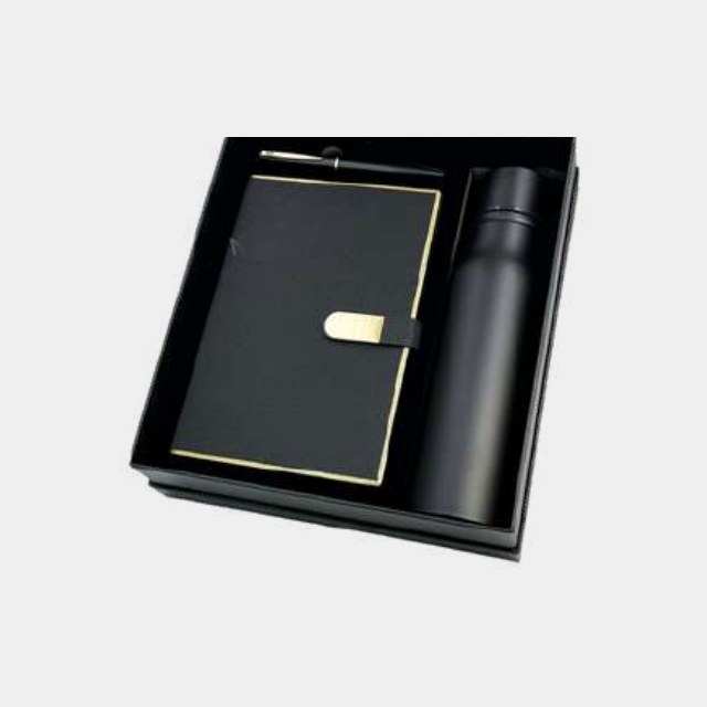Black notebook with gold page edging and gold trim, with a black insulated bottle