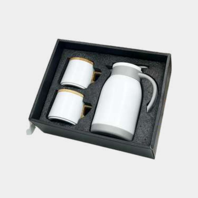 Compact white electric kettle with two gold-banded cups in a fitted gift box