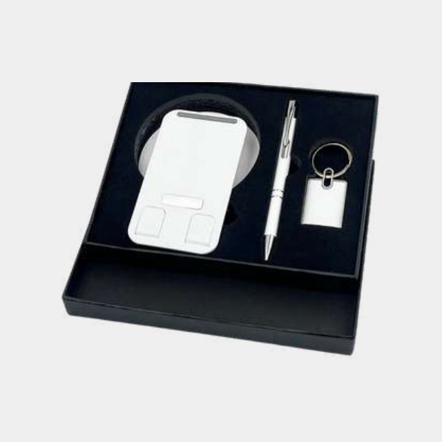 White 360-degree rotating phone stand with metal pen and keychain in a dark tray