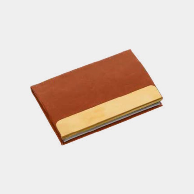 Tan leather card holder with a gold-tone metal edge and magnetic flap